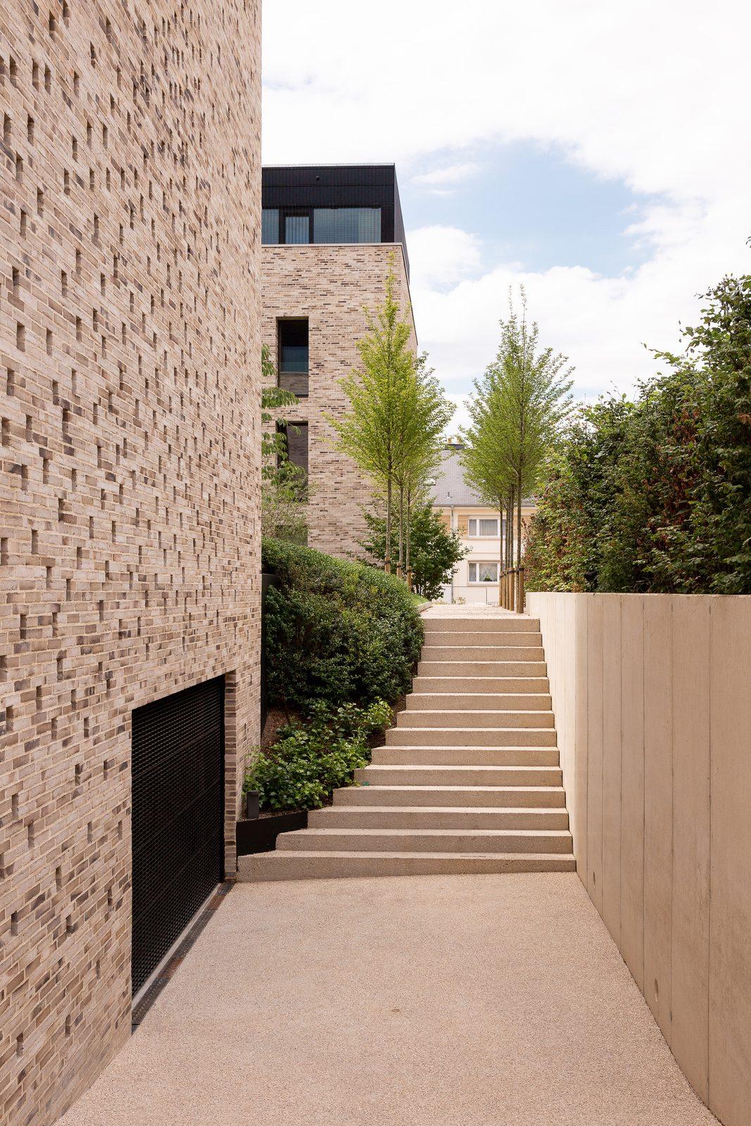 Brick buildings and a stone staircase through a garden